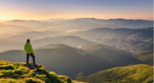 Man on top of a mountain looking at the horizon