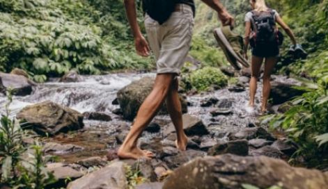 Two men walking down the river in the woods